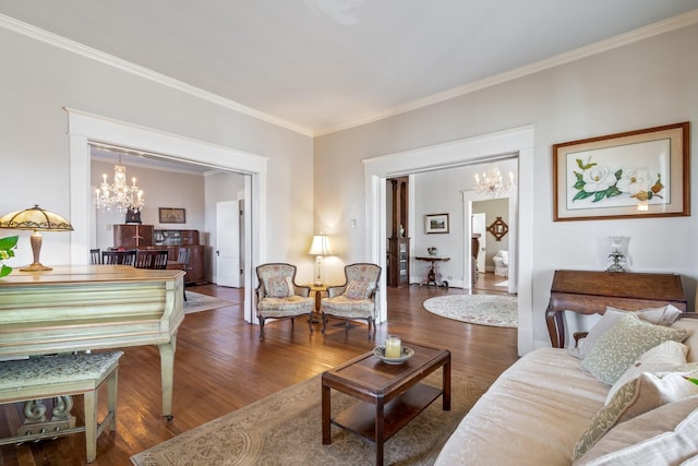living area with crown molding, an inviting chandelier, and wood finished floors