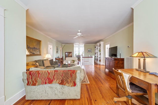 living room with a ceiling fan, baseboards, ornamental molding, and wood finished floors