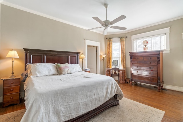 bedroom featuring baseboards, ornamental molding, a ceiling fan, and wood finished floors