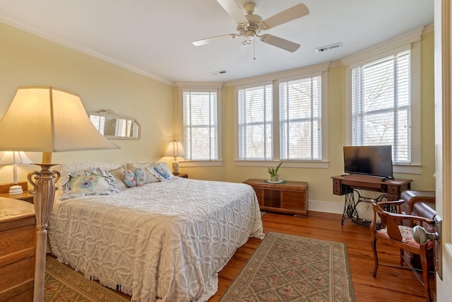 bedroom with multiple windows, wood finished floors, and visible vents