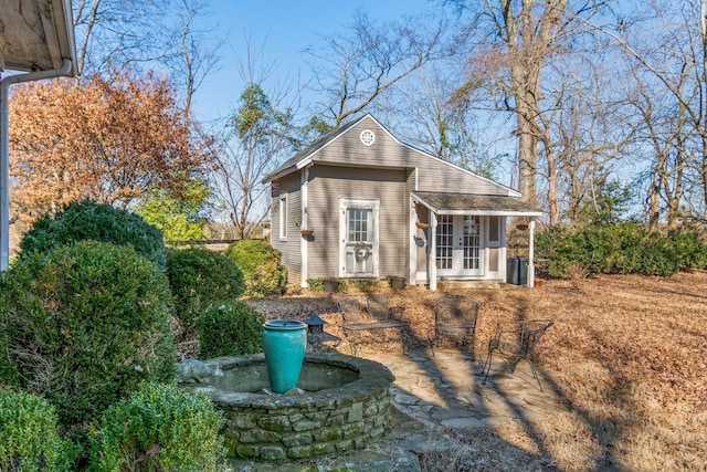 view of outdoor structure with central air condition unit, french doors, and an outdoor structure