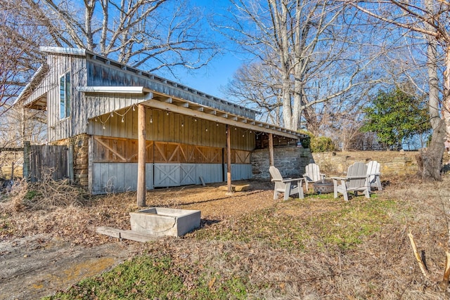 view of side of property featuring board and batten siding and an outdoor fire pit