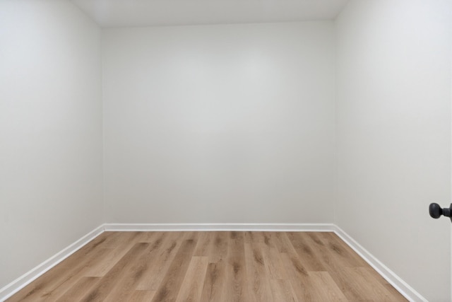 unfurnished room with baseboards and light wood-type flooring