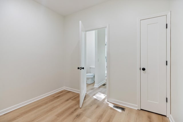 unfurnished bedroom with baseboards, light wood-style flooring, and visible vents