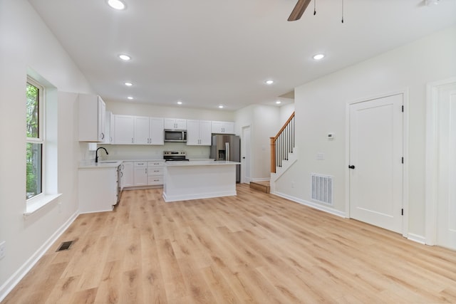 kitchen with a kitchen island, appliances with stainless steel finishes, a sink, and visible vents