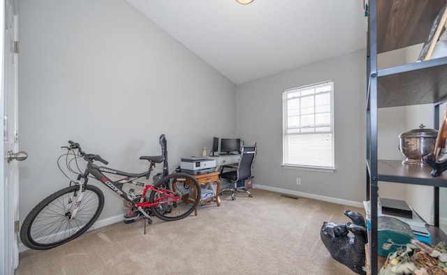office space featuring baseboards, carpet flooring, visible vents, and vaulted ceiling