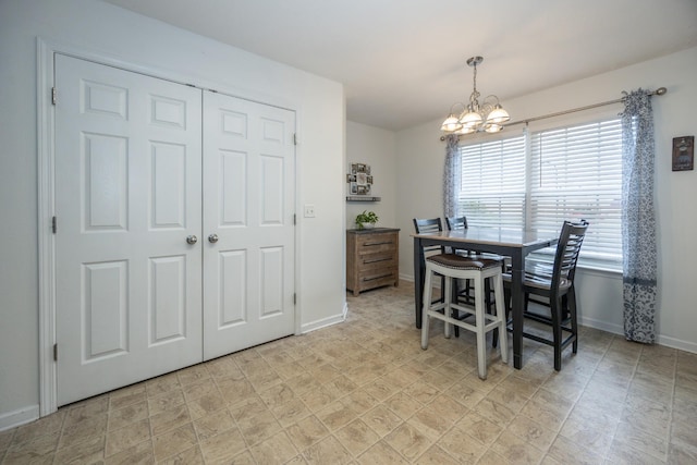 dining space featuring an inviting chandelier and baseboards