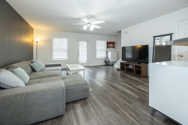 living area featuring baseboards, dark wood-style flooring, and ceiling fan