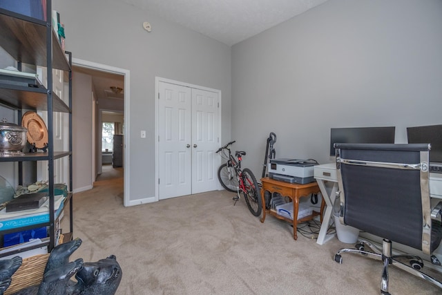 carpeted home office featuring baseboards