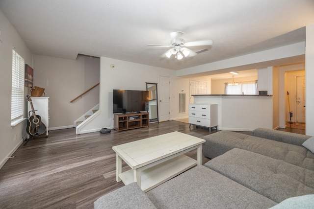 living area with ceiling fan, baseboards, visible vents, dark wood-style floors, and stairway