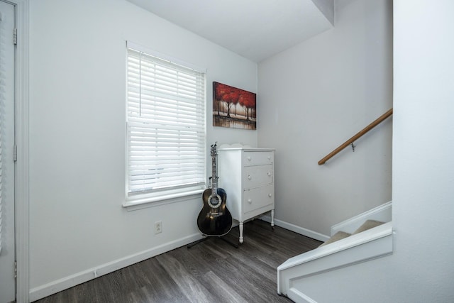 staircase featuring baseboards, a healthy amount of sunlight, and wood finished floors