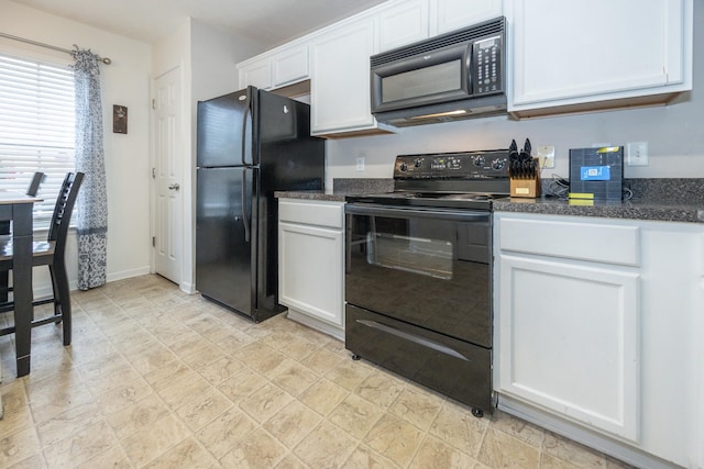 kitchen with baseboards, white cabinetry, black appliances, and stone finish floor