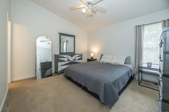 bedroom with light colored carpet, baseboards, vaulted ceiling, and a ceiling fan