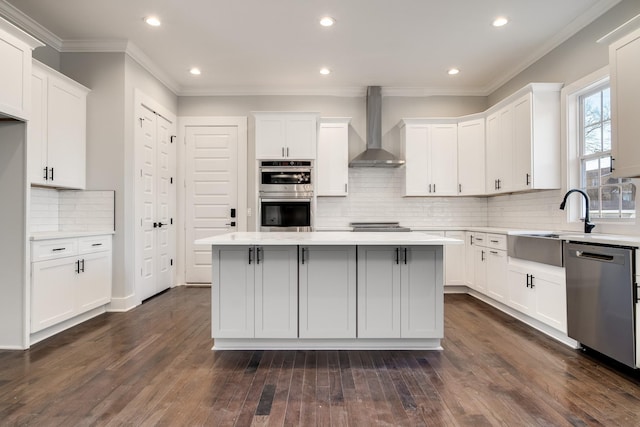 2509B Scovel St, Nashville, TN 37208 - kitchen featuring wall chimney range hood, crown molding, appliances with stainless steel finishes, light countertops, and a center island