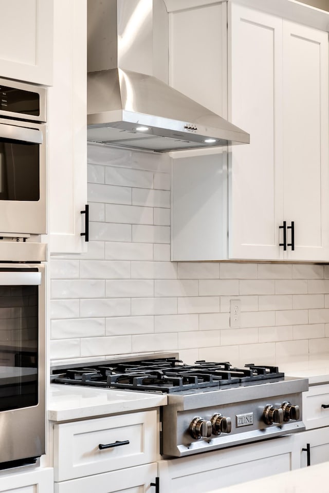 2509B Scovel St, Nashville, TN 37208 - kitchen featuring decorative backsplash, white cabinets, wall chimney range hood, and stainless steel appliances