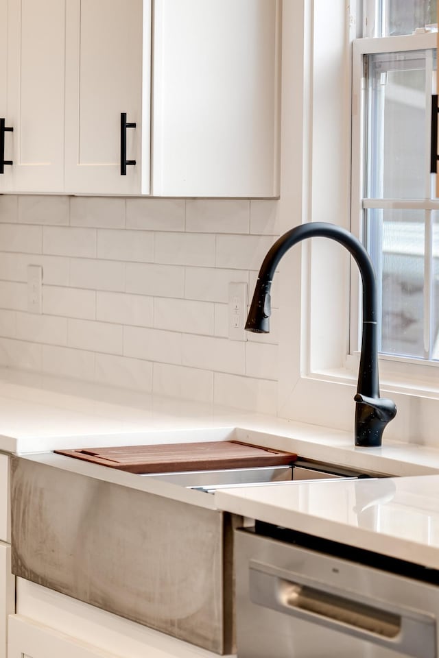 2509A Scovel St, Nashville, TN 37208 - room details with tasteful backsplash, stainless steel dishwasher, light countertops, a sink, and white cabinetry