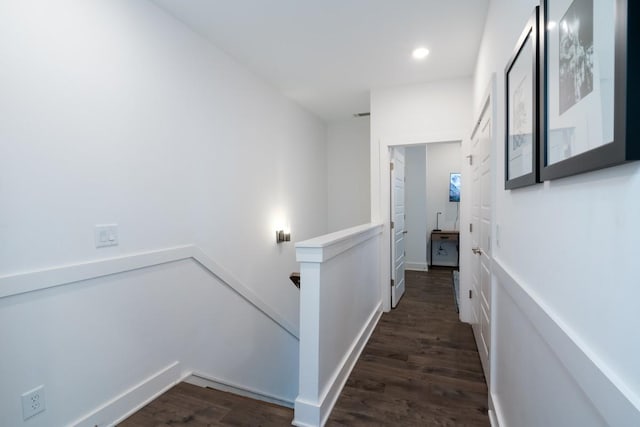 hallway featuring recessed lighting, dark wood-style flooring, and an upstairs landing