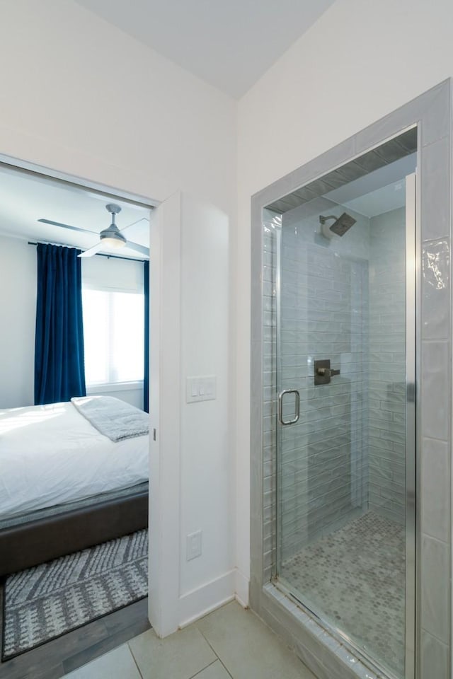 ensuite bathroom featuring tile patterned floors, baseboards, a stall shower, and connected bathroom