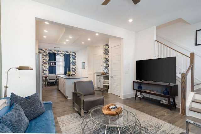 living area with recessed lighting, a ceiling fan, wood finished floors, and stairway