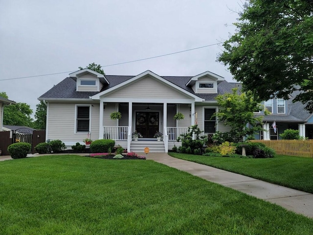 view of front of property with covered porch, a gate, fence, a shingled roof, and a front lawn