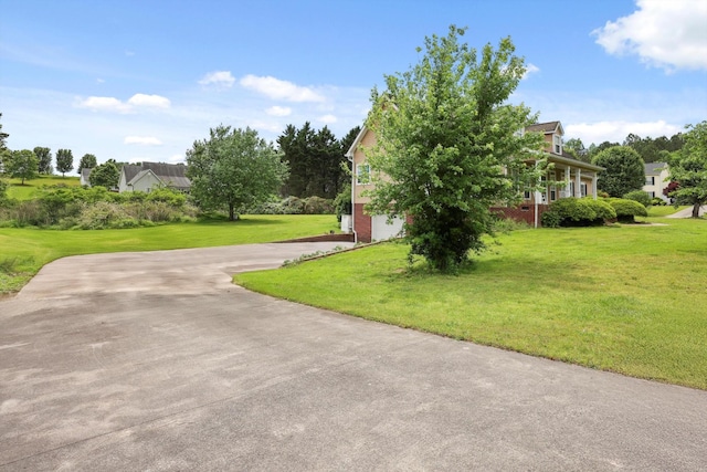 surrounding community with a garage, a yard, and driveway