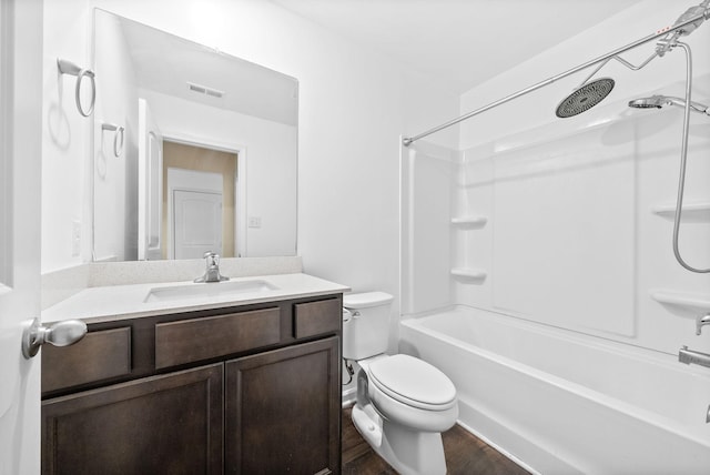 bathroom with toilet, wood finished floors, vanity, and  shower combination