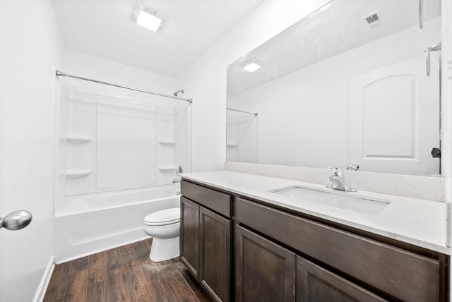 full bathroom with wood finished floors, toilet, vanity, shower / washtub combination, and baseboards