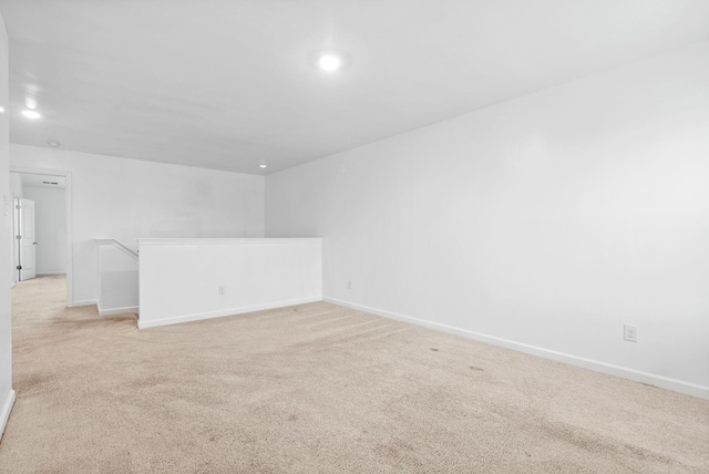 empty room with light colored carpet, baseboards, and recessed lighting