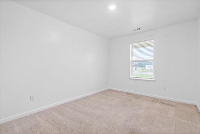 empty room featuring light colored carpet, baseboards, and recessed lighting