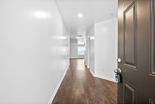 hallway with dark wood-style floors and baseboards