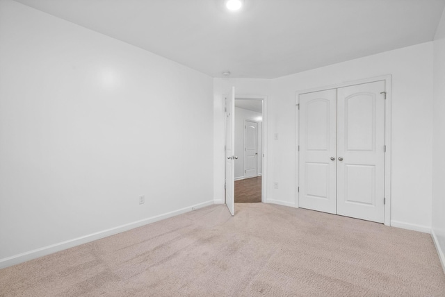 unfurnished bedroom featuring carpet, a closet, and baseboards