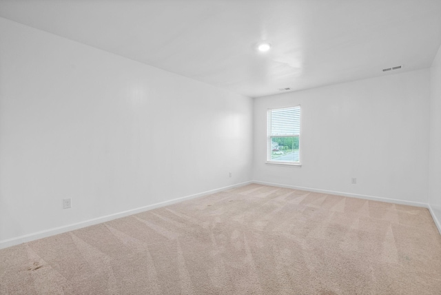 empty room with baseboards and light carpet