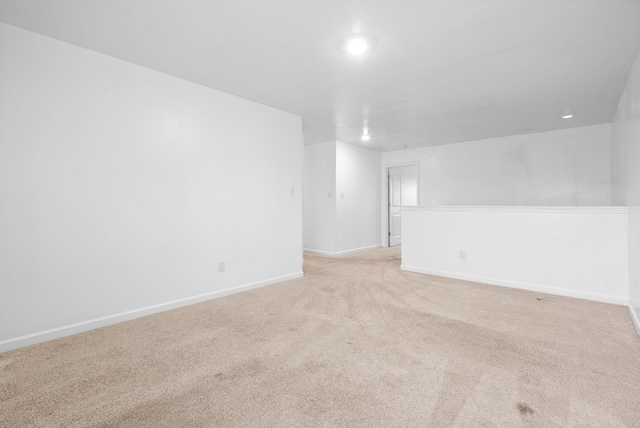 empty room featuring light colored carpet, recessed lighting, and baseboards