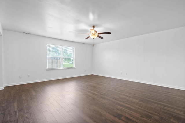 unfurnished room featuring a ceiling fan, dark wood-style flooring, and baseboards