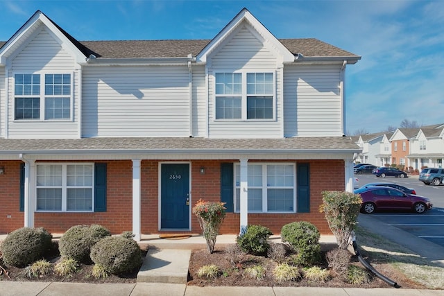 view of front of property featuring brick siding and uncovered parking