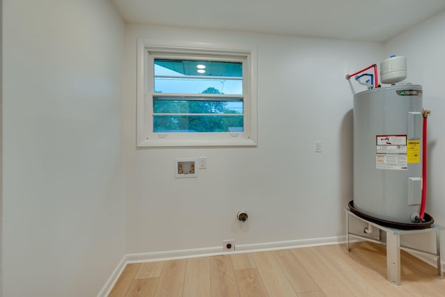 clothes washing area with light wood-style floors, hookup for an electric dryer, laundry area, hookup for a washing machine, and water heater