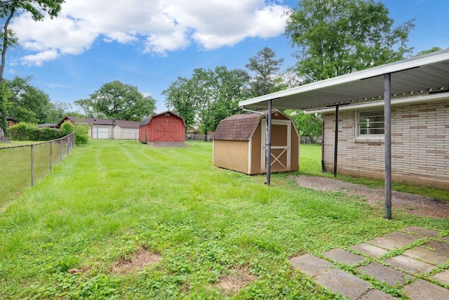 view of yard featuring fence, an outbuilding, and a shed