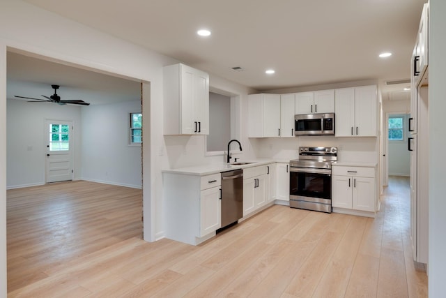 kitchen featuring a sink, light countertops, stainless steel appliances, and light wood-style flooring