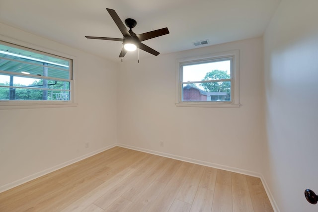 spare room with baseboards, visible vents, a wealth of natural light, and light wood-style flooring