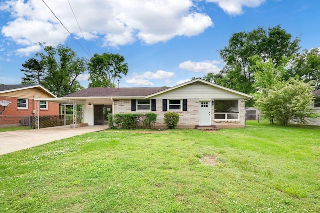 ranch-style house featuring fence, a front yard, driveway, and brick siding