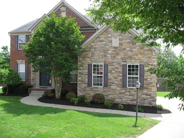 view of front of home featuring a front lawn and stone siding
