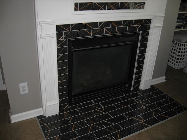 interior details featuring baseboards and a tile fireplace