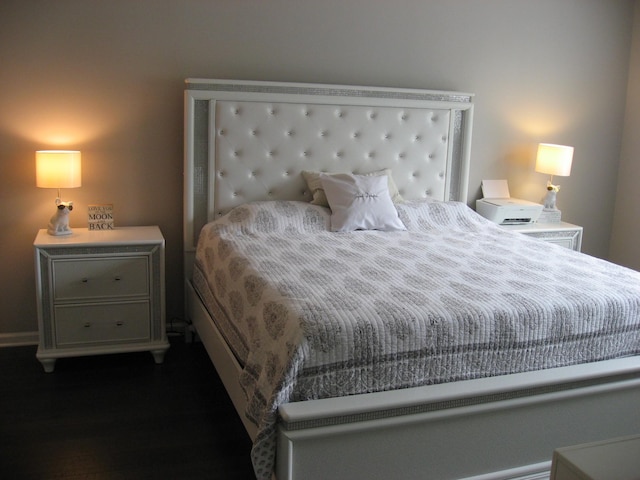 bedroom with baseboards and wood finished floors