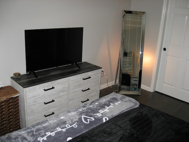 bedroom featuring baseboards and dark wood-style floors