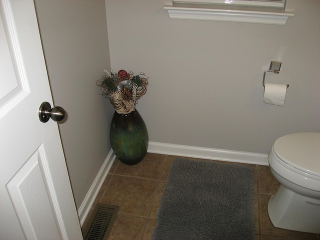 bathroom with tile patterned floors, toilet, visible vents, and baseboards