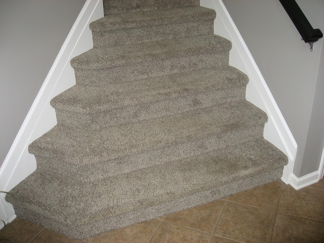 stairs featuring tile patterned floors and baseboards