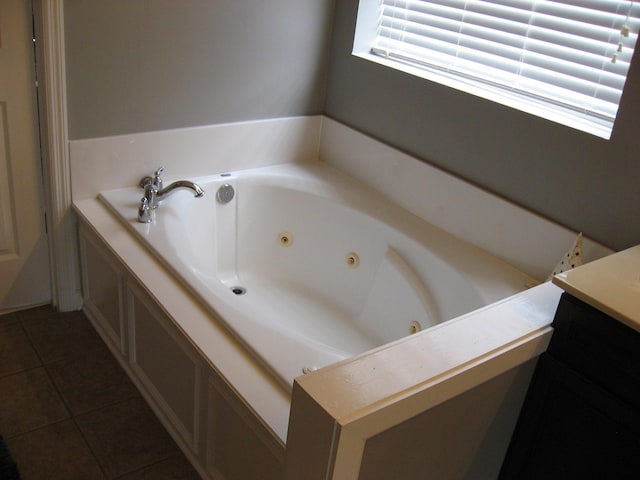 bathroom with a jetted tub and tile patterned floors