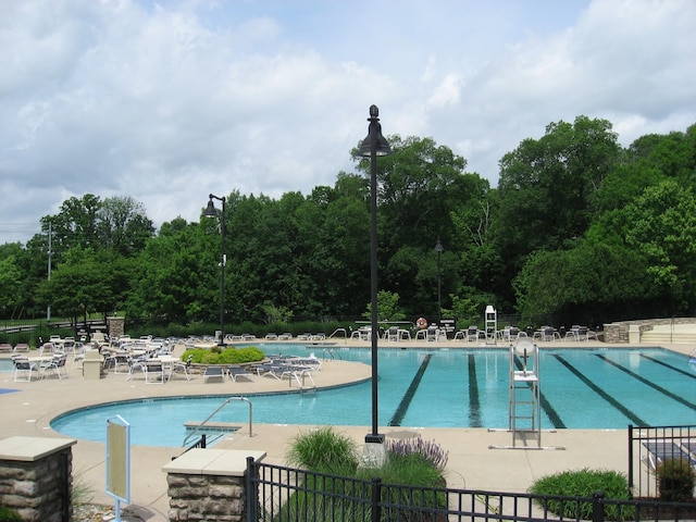 pool featuring a patio area and fence