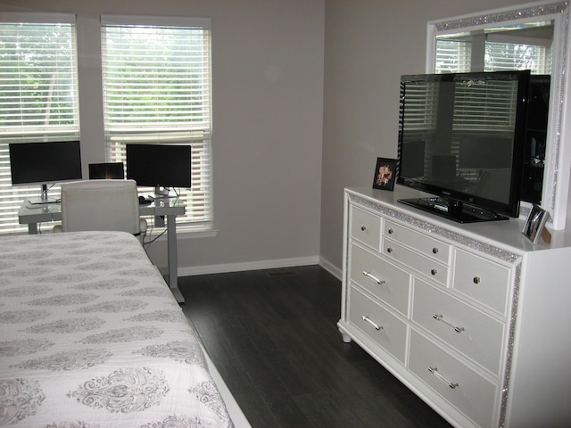 bedroom with baseboards and dark wood finished floors