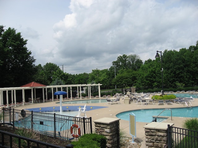 pool with a patio area, a pergola, and fence